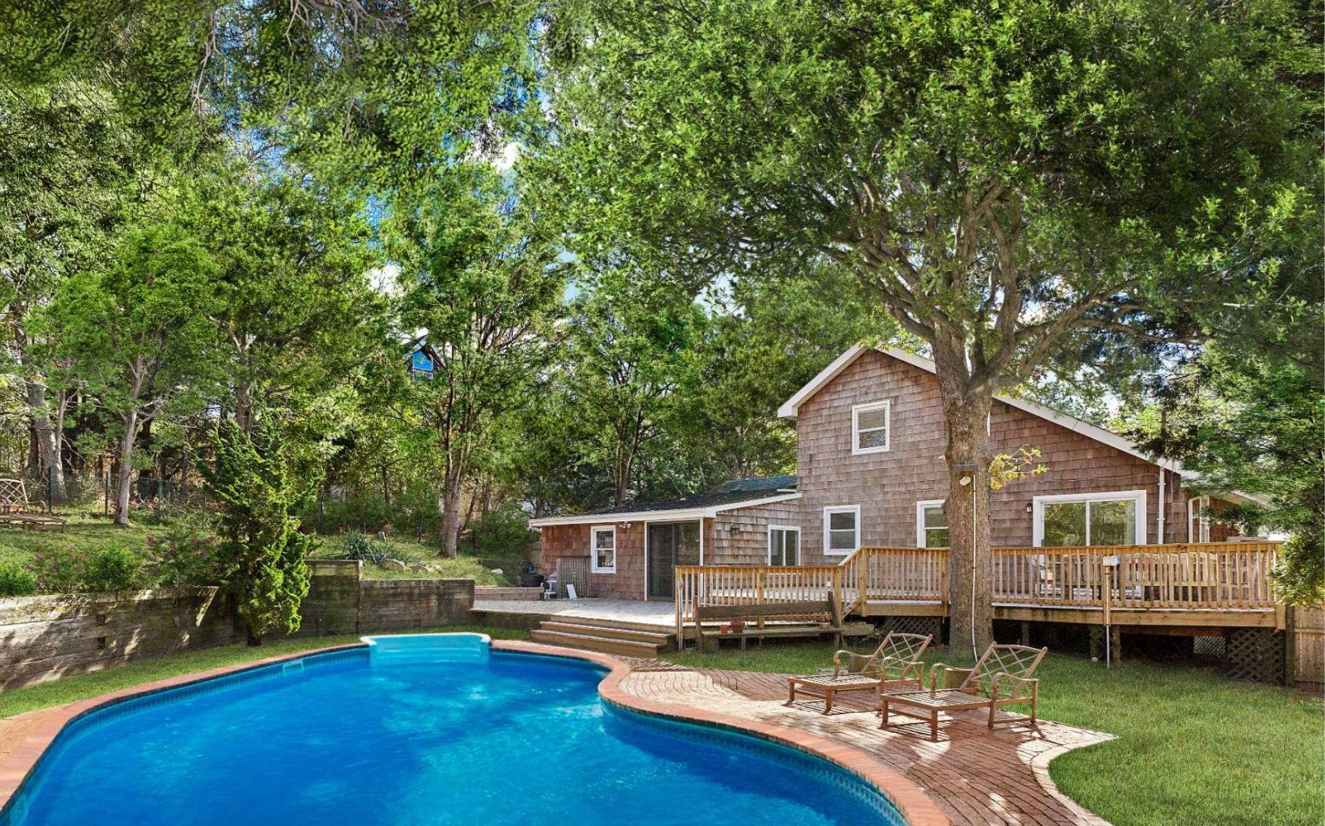 16 Peconic Road Hampton Bays, NY 11946 - Photo 15 of 17 a front view of a house with a garden and trees