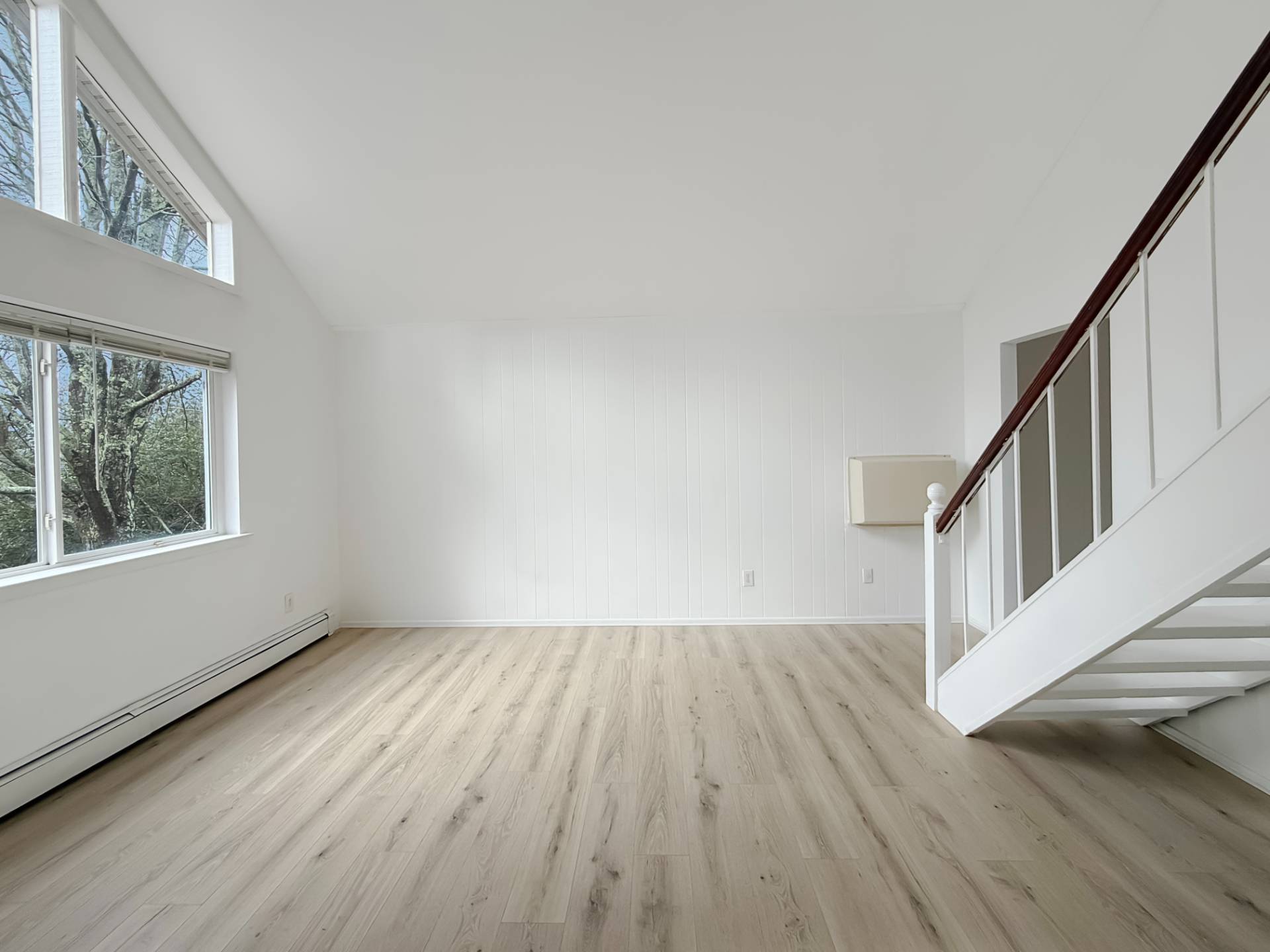 16 Peconic Road Hampton Bays, NY 11946 - Photo 3 of 17 a view of an empty room with wooden floor and a window