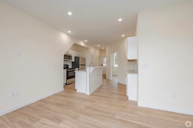 a view of kitchen with kitchen island microwave and refrigerator