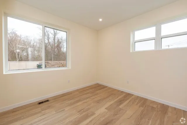 wooden floor in an empty room with a window