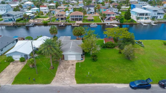an aerial view of residential houses with outdoor space and lake view