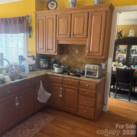 a kitchen with stainless steel appliances granite countertop a sink a stove and a refrigerator