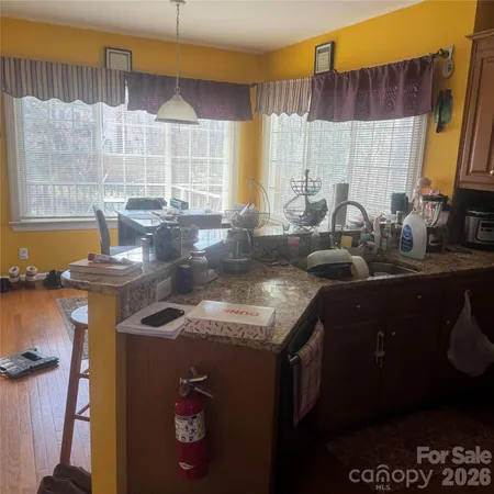a kitchen with granite countertop a sink a stove and a wooden cabinets