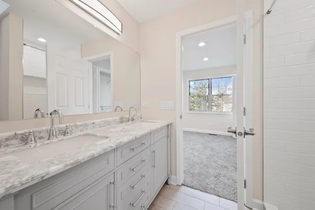 a bathroom with a granite countertop sink and a bathtub