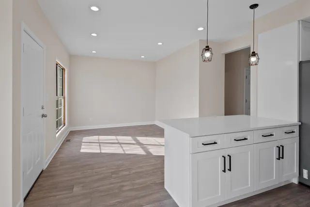 a view of an empty room with wooden floor