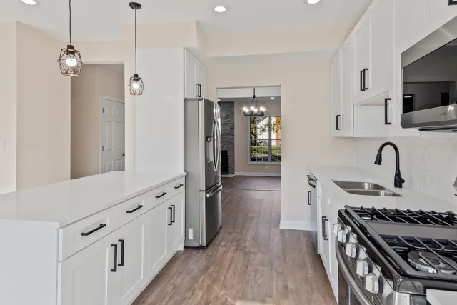 a kitchen with stainless steel appliances a stove a sink and a refrigerator