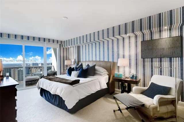 a bedroom with furniture and a large window