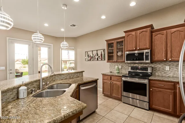 a kitchen with stainless steel appliances granite countertop a stove sink and microwave