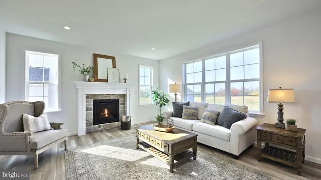 a living room with furniture a fireplace and a large window