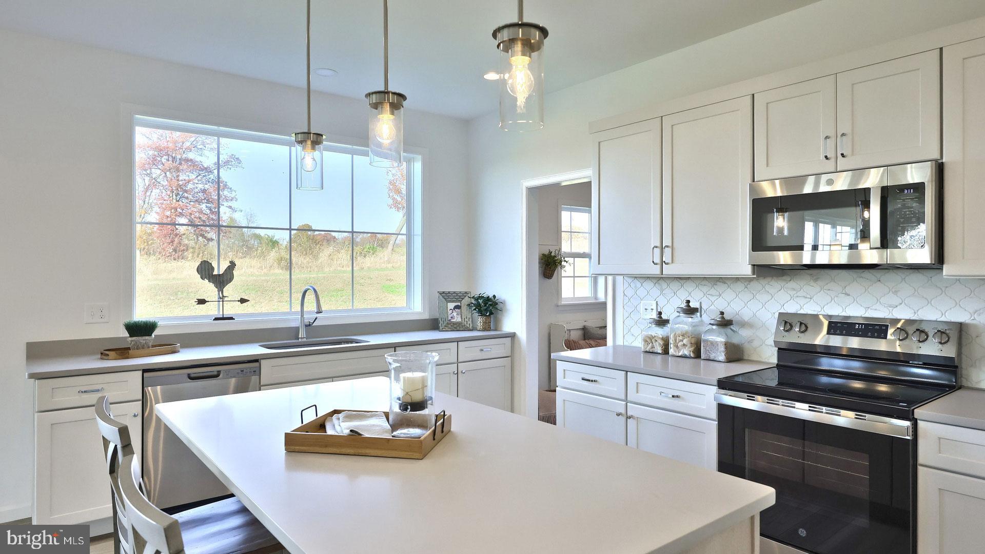 157 Copper Ridge Drive Newmanstown, PA 17073 - Photo 6 of 33 a kitchen with stainless steel appliances a white table chairs and a stove