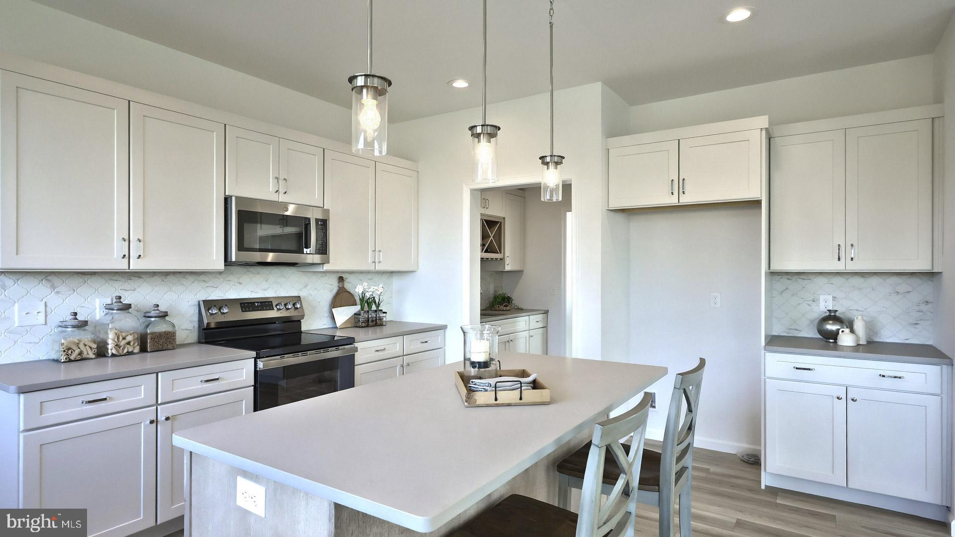 157 Copper Ridge Drive Newmanstown, PA 17073 - Photo 9 of 33 a kitchen with white cabinets stainless steel appliances and kitchen island