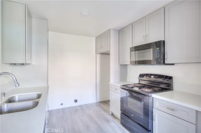 a kitchen with microwave a stove and cabinets