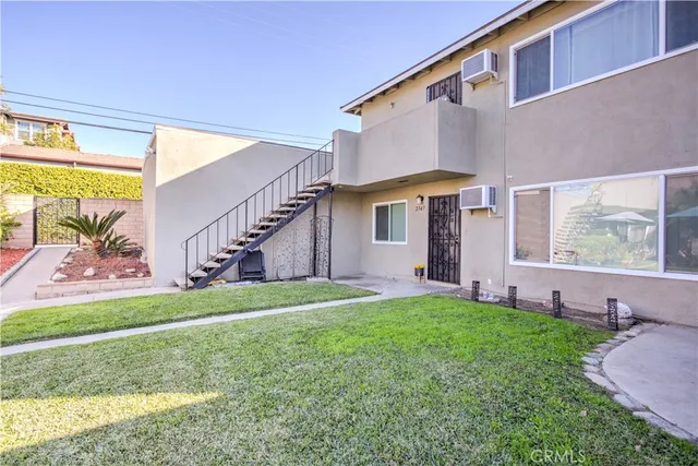 a view of a house with a yard and a large tree
