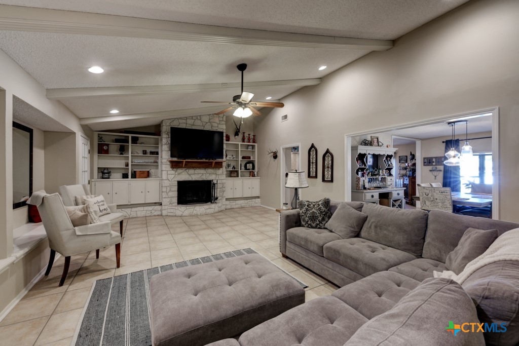 1229 Rapids Road New Braunfels, TX 78130 - Photo 6 of 27 a living room with furniture a flat screen tv and a fireplace