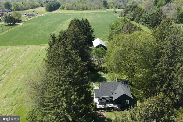 an aerial view of residential house with outdoor space and trees all around