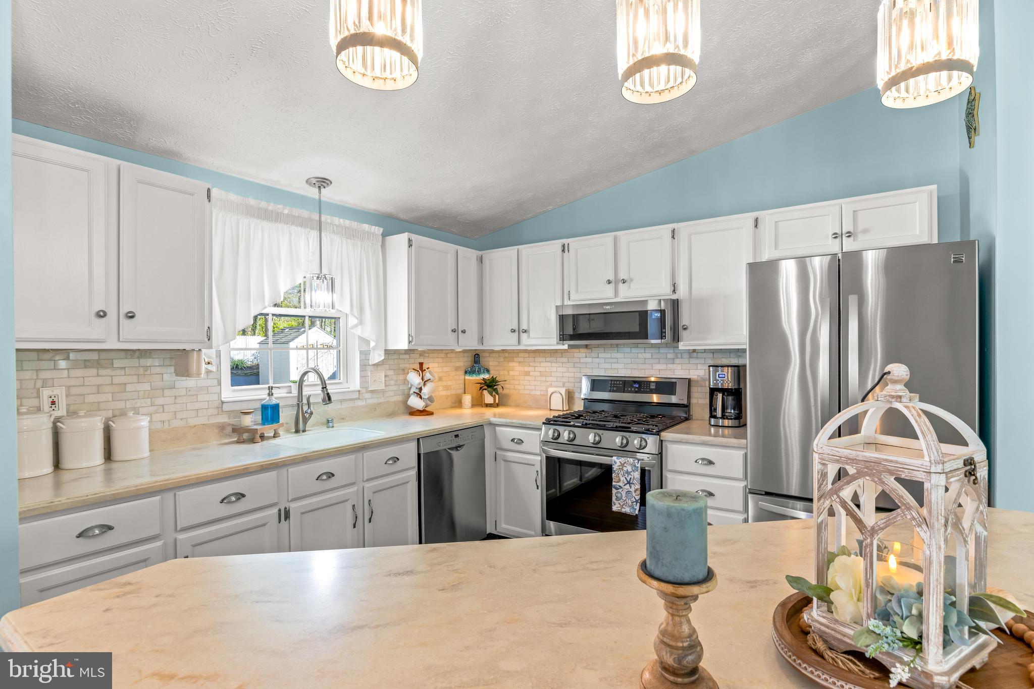 15 Yew Road Baltimore, MD 21221 - Photo 20 of 61 a kitchen with stainless steel appliances a stove a sink a refrigerator cabinets and a window