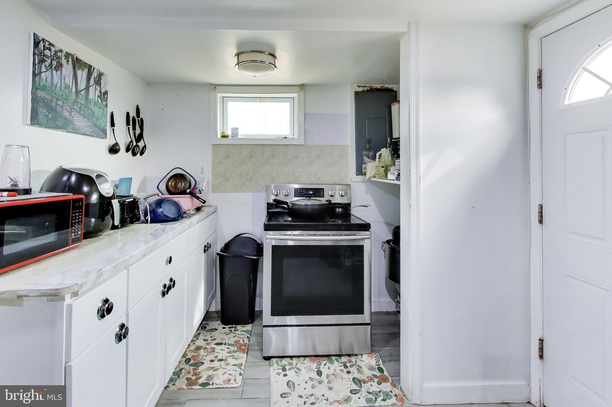 1028 Ward Street Laurel, MD 20707 - Photo 24 of 39 a kitchen with a sink and a stove with white cabinets