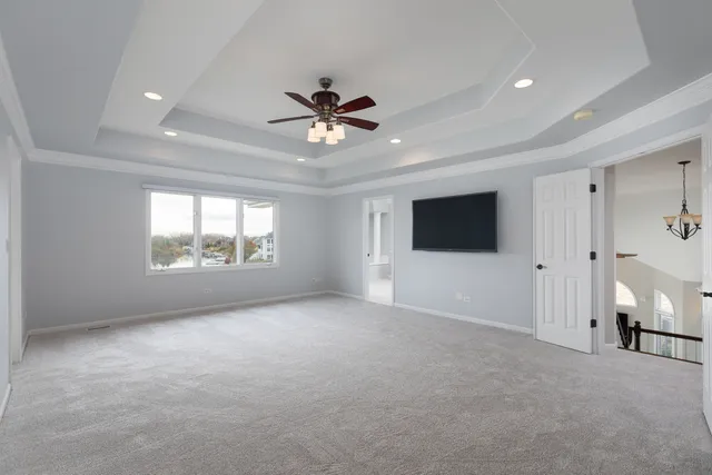 a dining room with wooden floor a chandelier fan a wooden table and chairs