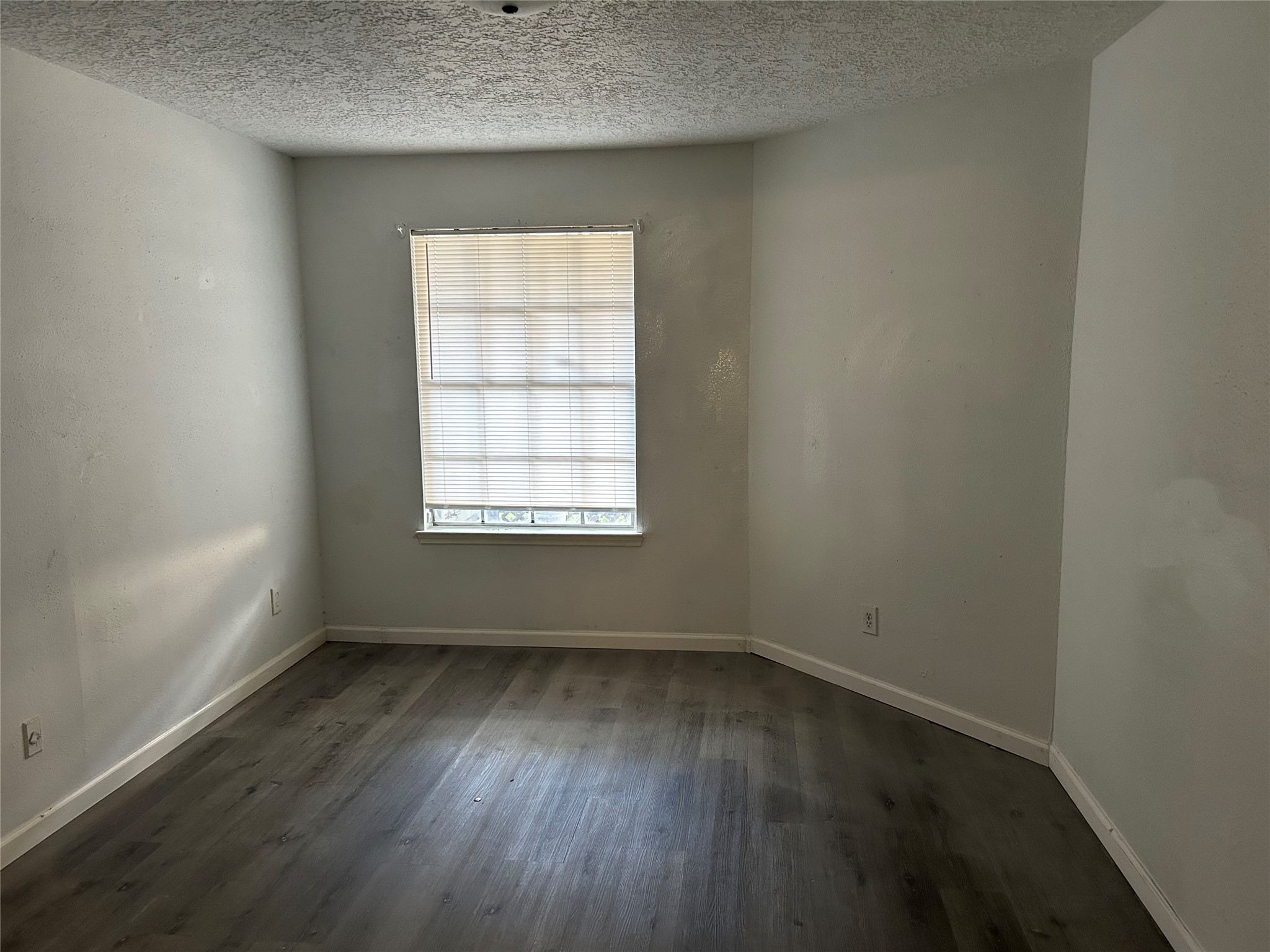 9700 Leawood Boulevard, Unit 1407 Houston, TX 77099 - Photo 3 of 10 an empty room with wooden floor and windows