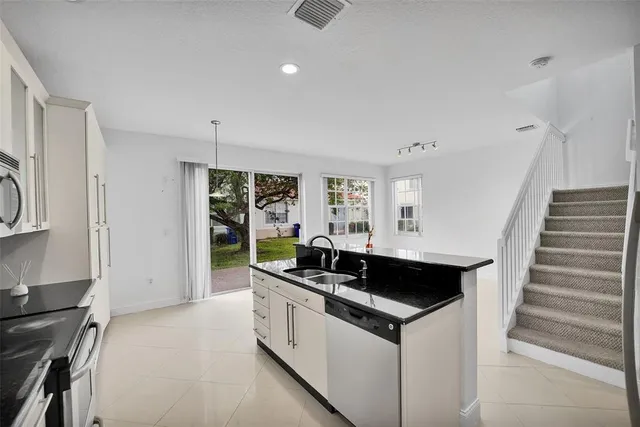 a kitchen that has a sink and a stove in it