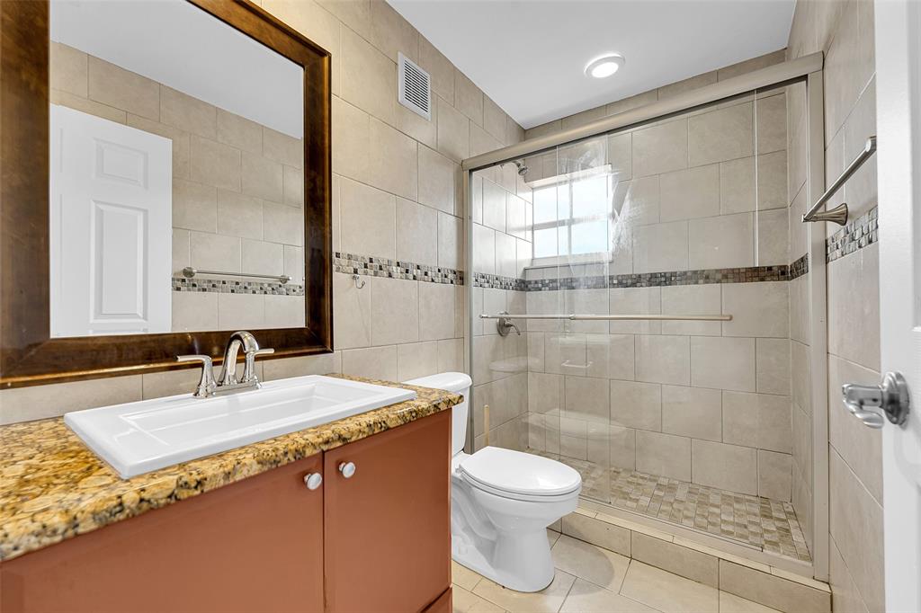 2634 Southwest 188th Avenue, Unit 2634 Miramar, FL 33029 - Photo 24 of 48 a bathroom with a granite countertop sink a toilet and shower
