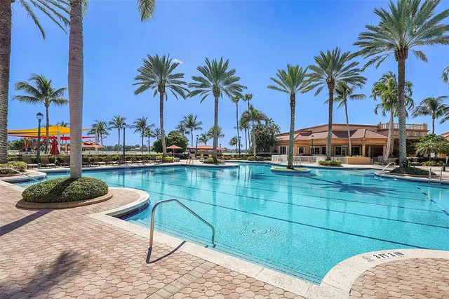 a view of a swimming pool with a seating space and potted plants