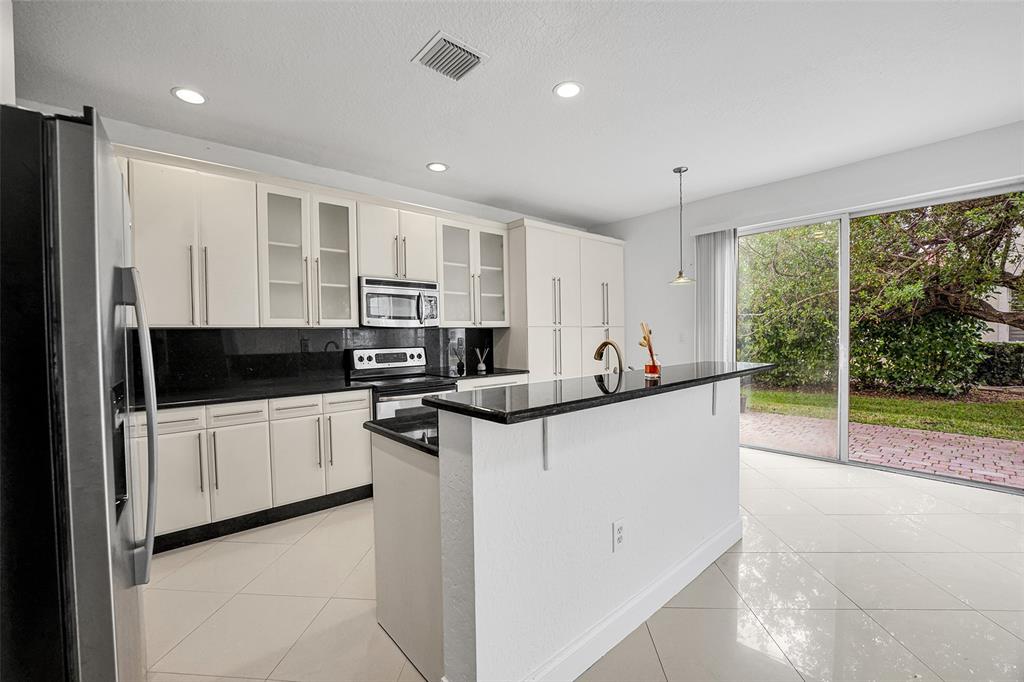 2634 Southwest 188th Avenue, Unit 2634 Miramar, FL 33029 - Photo 7 of 48 a kitchen with stainless steel appliances granite countertop a stove and a refrigerator
