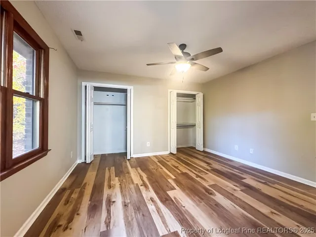 a view of a livingroom with a chandelier fan and windows