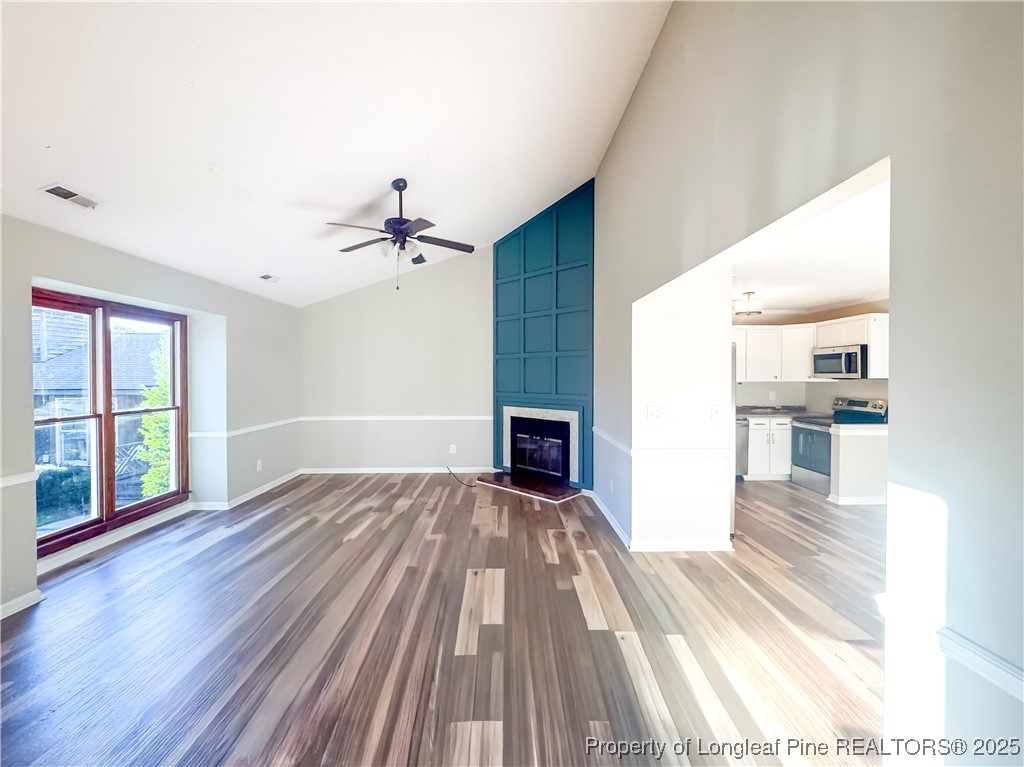 527 Coronation Drive Fayetteville, NC 28311 - Photo 4 of 16 wooden floor in an empty room with a fireplace and a window