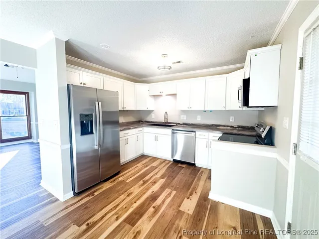 a kitchen with granite countertop a refrigerator and a sink