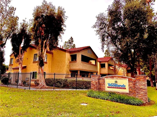 a front view of a house with swimming pool and trees
