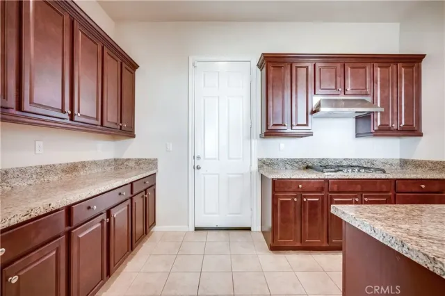 an empty room with windows and chandelier fan
