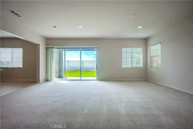 a view of an empty room with furniture and a kitchen