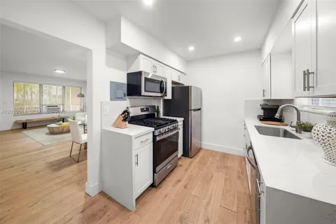 a kitchen with a sink a counter top space stainless steel appliances and a window