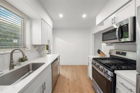 a kitchen with stainless steel appliances a sink stove and microwave