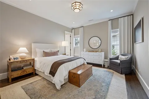 a spacious bedroom with a bed a couch and a chandelier