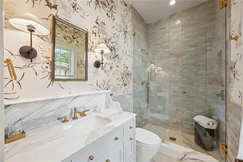 a bathroom with a sink a toilet and shower