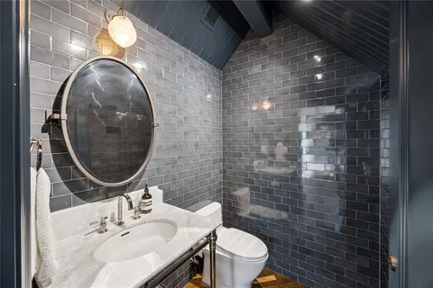 a bathroom with a sink mirror and toilet