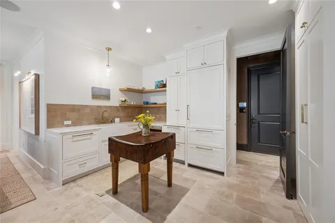 a kitchen with a refrigerator and white cabinets