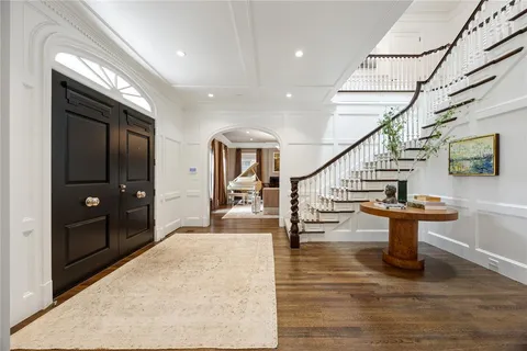 a view of entryway and hall with wooden floor