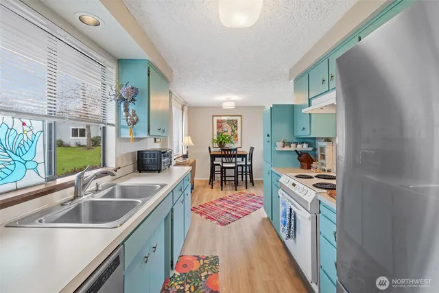 a kitchen with stainless steel appliances granite countertop a sink stove and cabinets