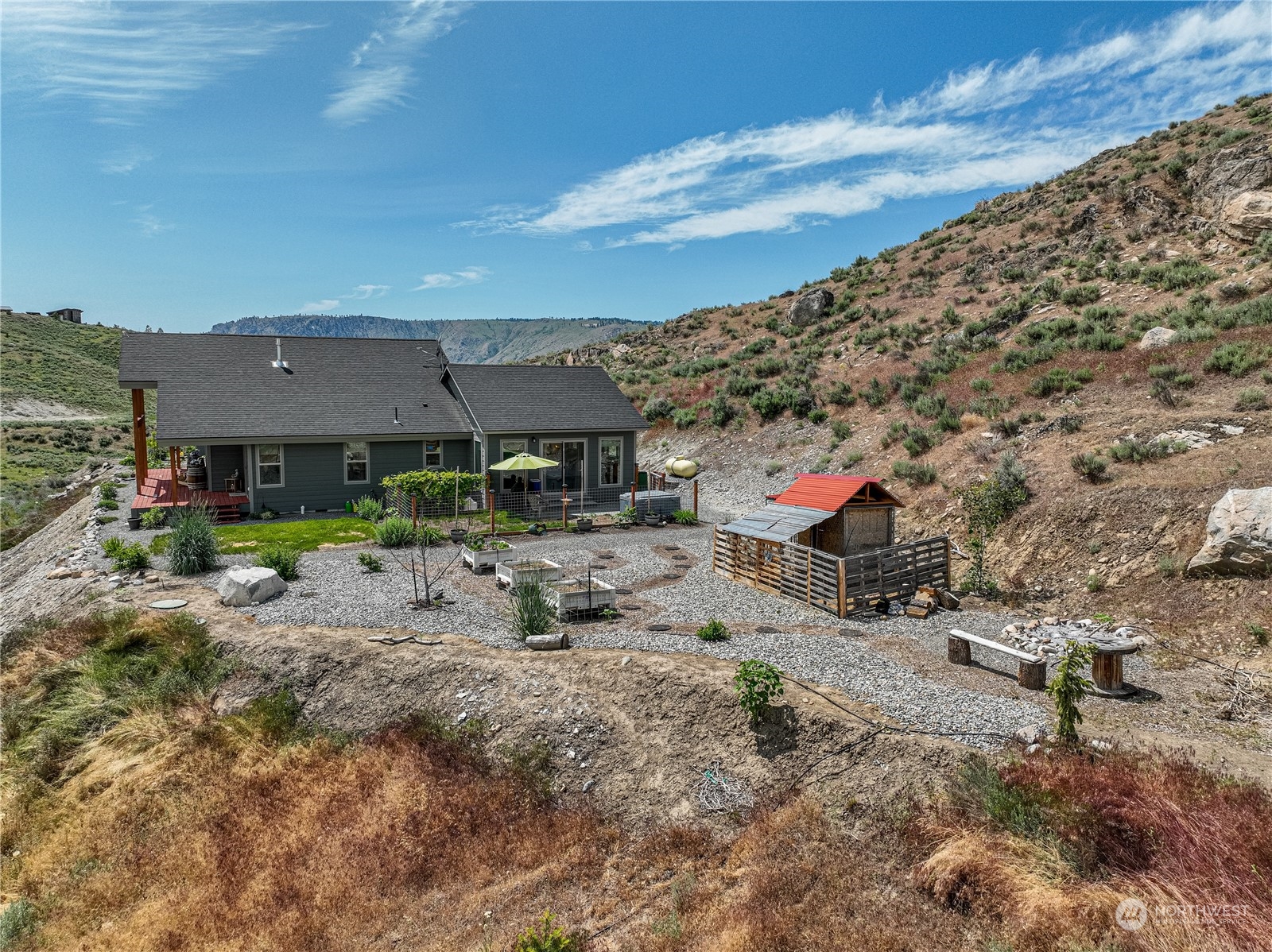 471 A Plata Road Brewster, WA 98812 - Photo 36 of 36 a view of a yard with a table and chairs under an umbrella