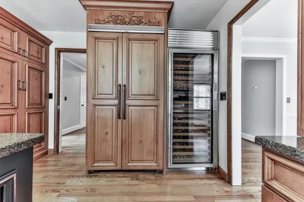 an entrance view of a hallway with wooden floor and staircase