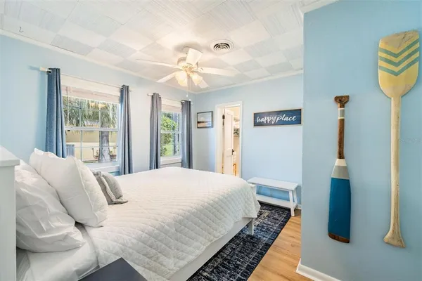a bedroom with a bed and wooden floor