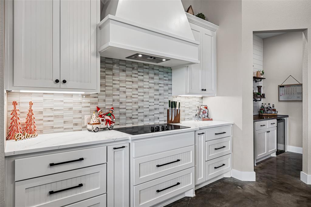 310 Runyan Rnch Road Tolar, TX 76476 - Photo 10 of 35 Kitchen featuring premium range hood, white cabinetry, concrete flooring, light stone countertops, and black electric stovetop
