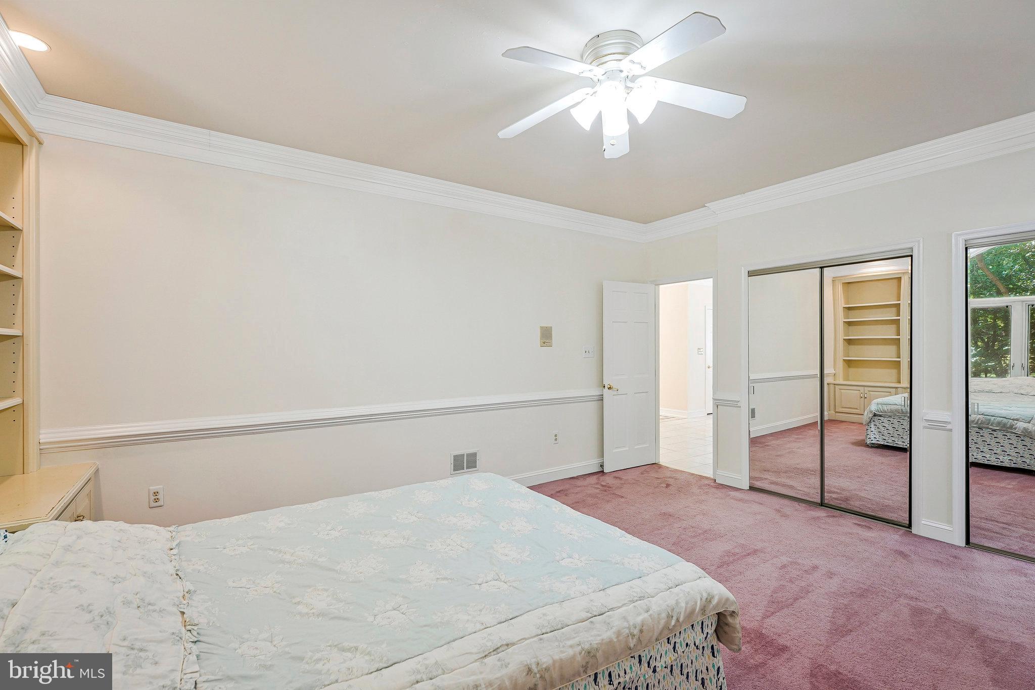 8652 Tuttle Road Springfield, VA 22152 - Photo 37 of 102 a bedroom with a large bed and a chandelier