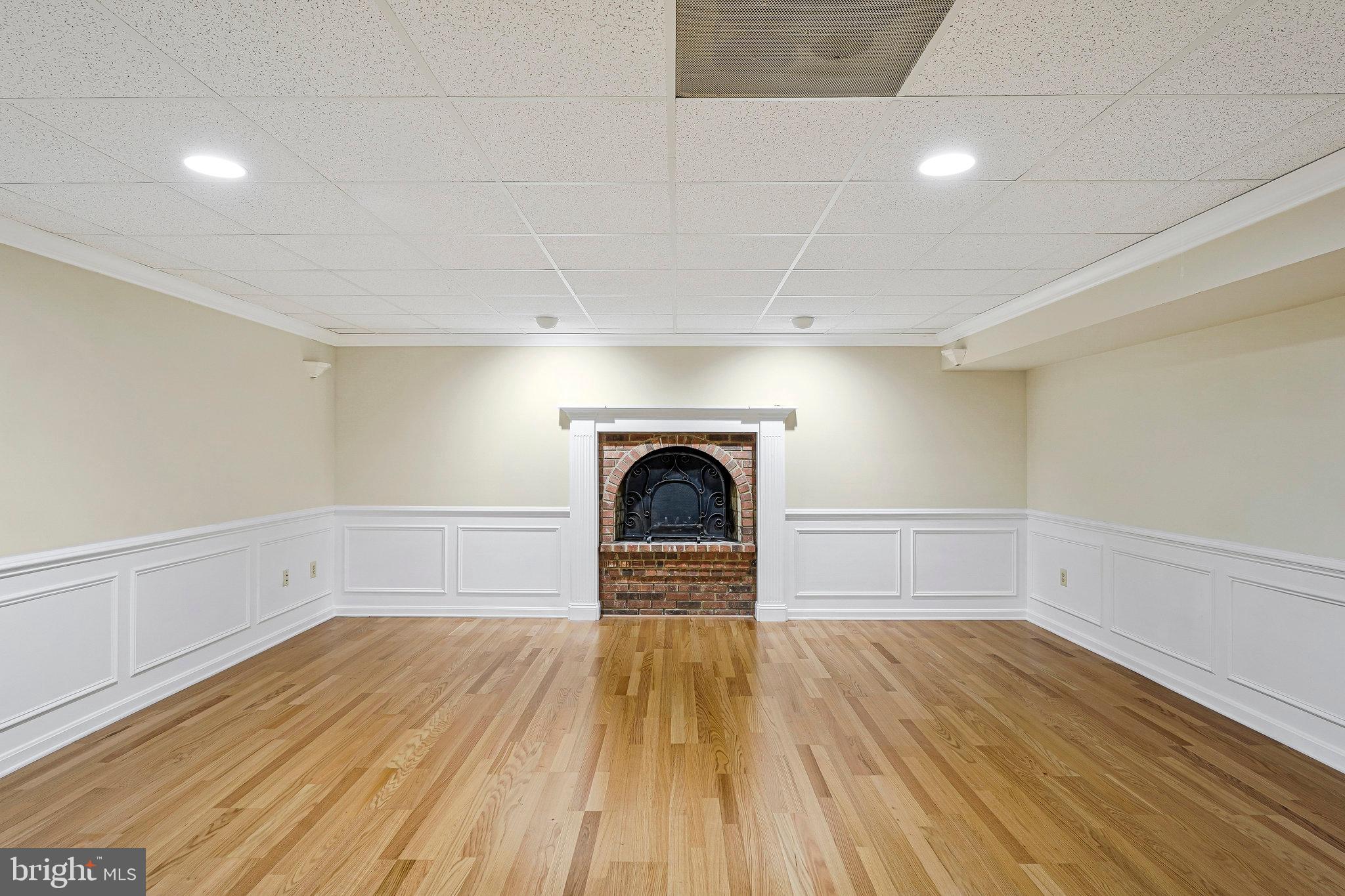 8652 Tuttle Road Springfield, VA 22152 - Photo 67 of 102 a view of empty room with wooden floor and fireplace