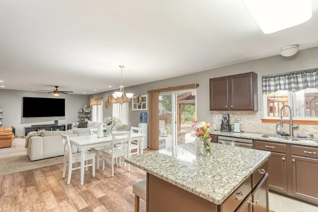 a view of a kitchen with kitchen island granite countertop a table and chairs