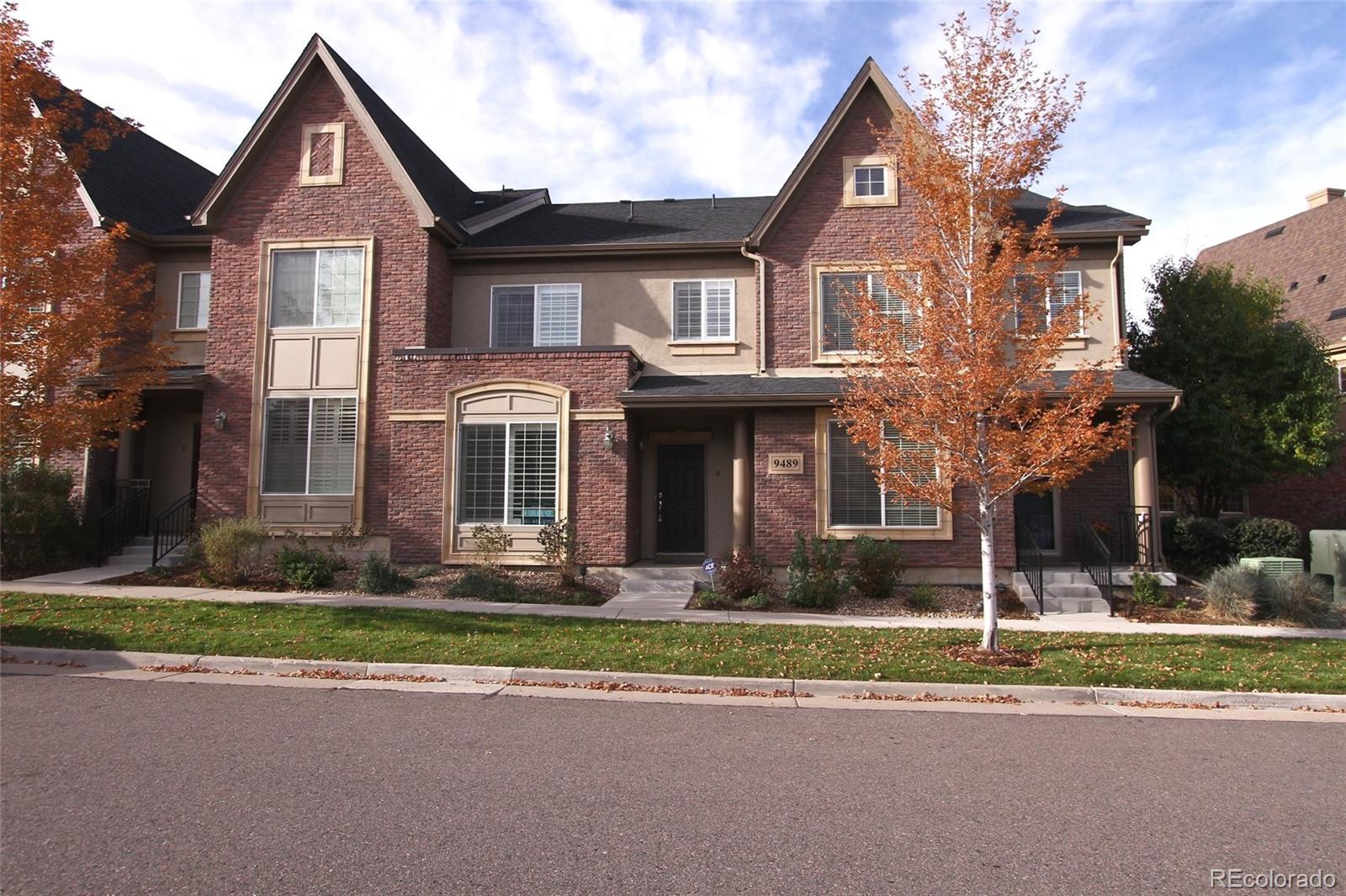9489 Cedarhurst Lane, Unit B Highlands Ranch, CO 80129 - Photo 1 of 20 a front view of a house with a yard