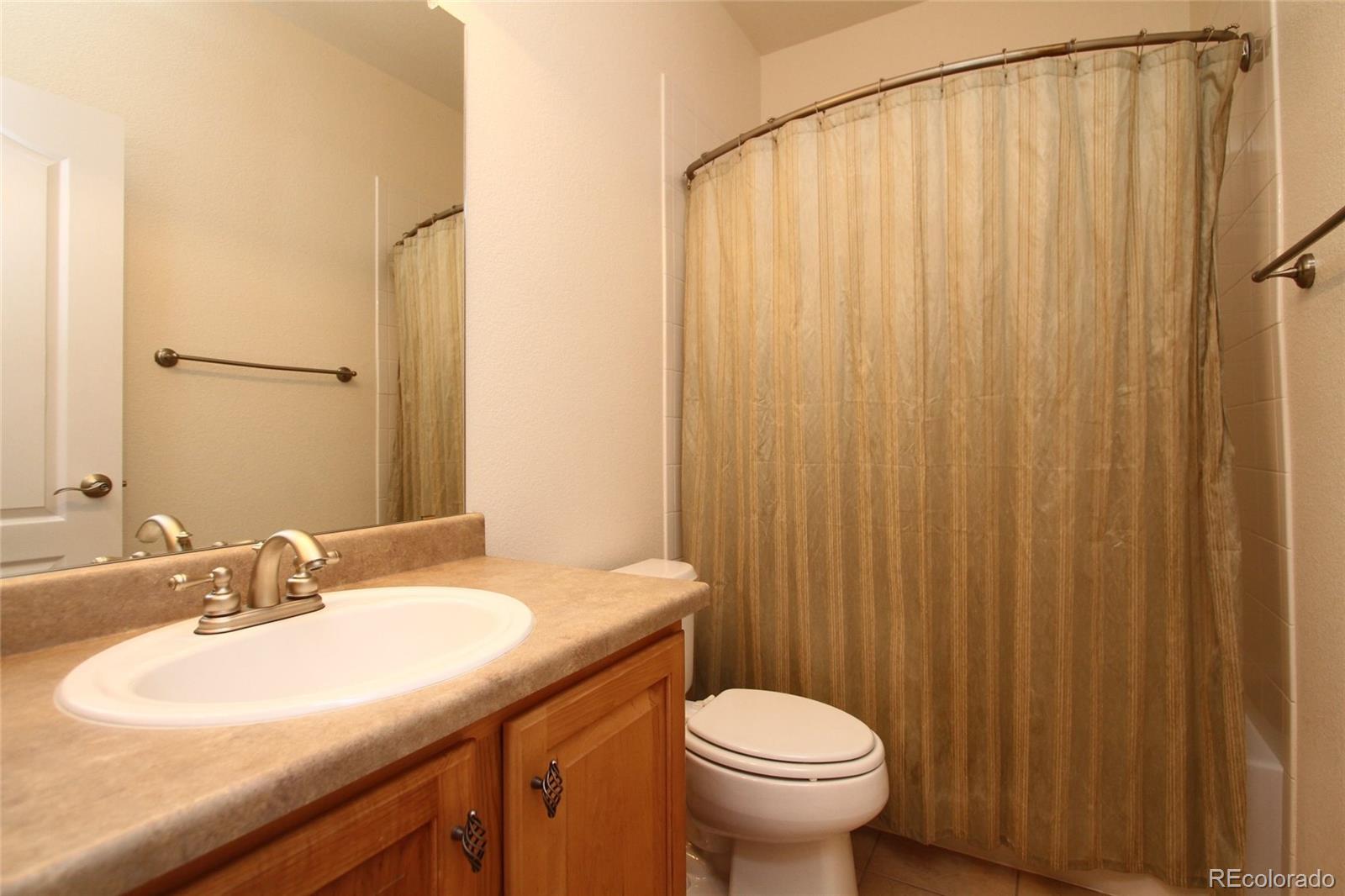 9489 Cedarhurst Lane, Unit B Highlands Ranch, CO 80129 - Photo 16 of 20 a bathroom with a sink a toilet and shower